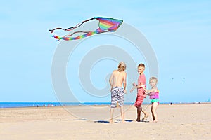 Happy kids flying kite on the beach