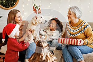 Happy kids getting dog for Christmas, multiethnic family with golden retriever celebrate New Year