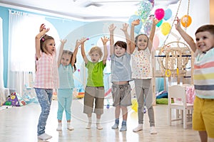 Happy kids with hands up at daycare