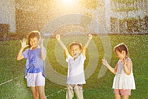 Happy kids has fun playing in water fountains