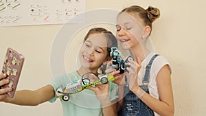 Happy kids have fun and laugh while doing selfie with robot cars at the class slow motion