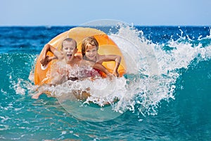 Happy kids have fun in sea surf on beach