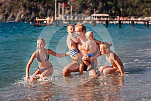 Happy kids with his father on the beach having fun