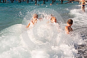 Happy kids with his father on the beach having fun