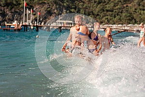 Happy kids with his father on the beach having fun