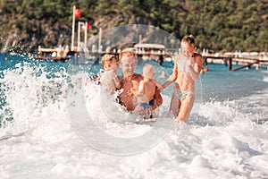 Happy kids with his father on the beach having fun