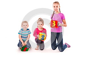 Happy kids holding blocks with numbers over white background