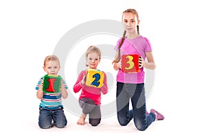 Happy kids holding blocks with numbers over white background