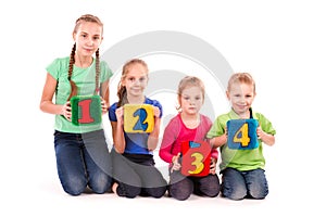 Happy kids holding blocks with numbers over white background