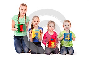 Happy kids holding blocks with numbers over white background