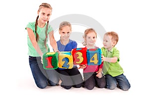 Happy kids holding blocks with numbers over white background