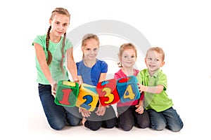 Happy kids holding blocks with numbers over white background