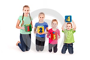 Happy kids holding blocks with numbers over white background