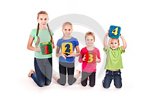 Happy kids holding blocks with numbers over white background