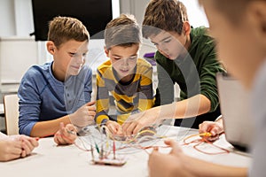 Happy kids with invention kit at robotics school photo