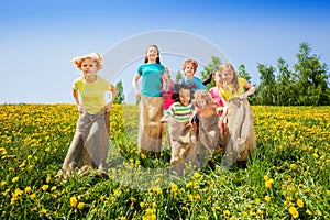 Happy kids jumping in sacks playing together