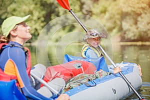 Happy kids kayaking on the river on a sunny day during summer vacation