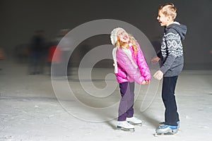 Happy kids laughing at ice rink outdoor, ice skating