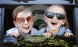 Happy kids looking out the car window