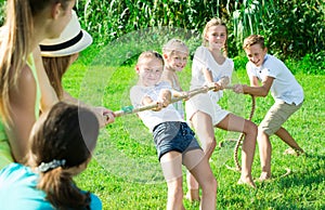 Happy kids with parents playing tug of war
