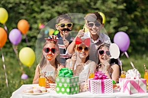 Happy kids with party props at summer birthday