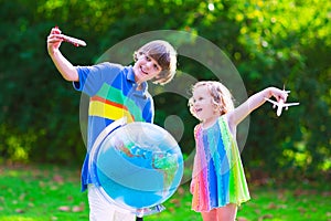 Happy kids playing with airplanes and globe