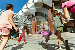 Happy kids playing at city`s street in sunny summer`s day