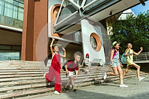 Happy kids playing at city`s street in sunny summer`s day