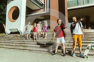 Happy kids playing at city`s street in sunny summer`s day