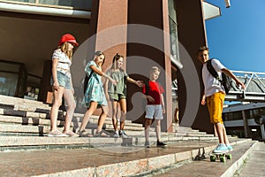 Happy kids playing at city`s street in sunny summer`s day