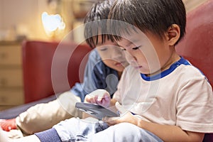 Happy kids playing online game with mobile phone