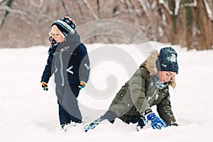 Happy kids playing outdoors with snow. Little brothers aving fun in winter park. Happy and healthy childhood. Winter holidays