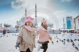 happy kids playing with pigeons in taksim square turkey photo