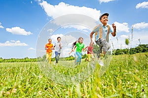 Happy kids playing and running in the field