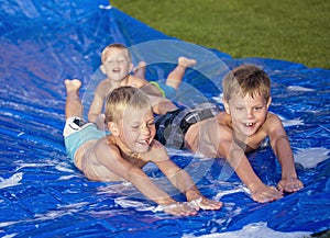 Happy kids playing on a slip and slide outdoors