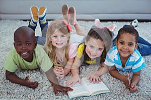 Happy kids reading a book together