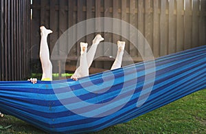 happy kids relaxing in a hammock outdoor. children\'s feet barefoot. Holidays vacation