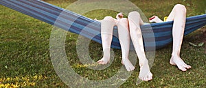 happy kids relaxing in a hammock outdoor. children's feet barefoot. Holidays vacation.banner.