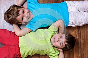 Happy kids relaxing laying on floor- top view