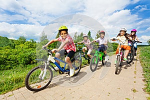 Happy kids riding bikes like in race together