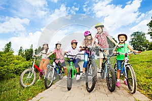 Happy kids in row wear colorful bike helmets