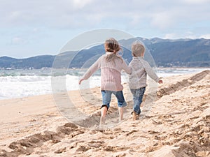 Happy kids running on the beach on vacation