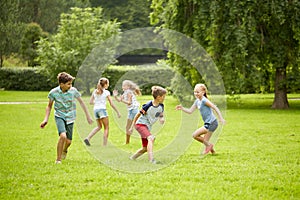 Happy kids running and playing game outdoors photo