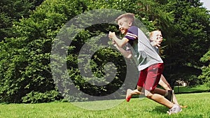 Happy kids running and playing tag game outdoors