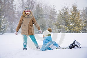 Happy kids running on snowy spruce forest.