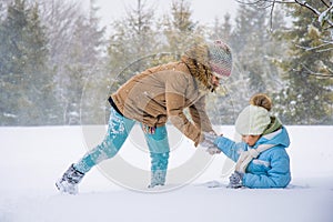 Happy kids running on snowy spruce forest.