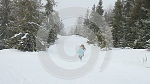 Happy kids running on snowy spruce forest.