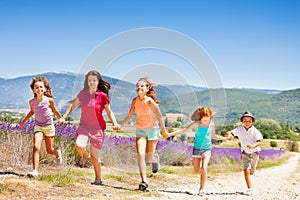 Happy kids running together through lavender field