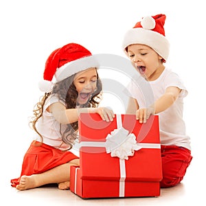 Happy kids in Santa hat opening a gift box