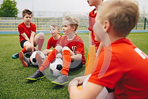 Happy kids in school sports team. Boys gathering and having fun on sports field